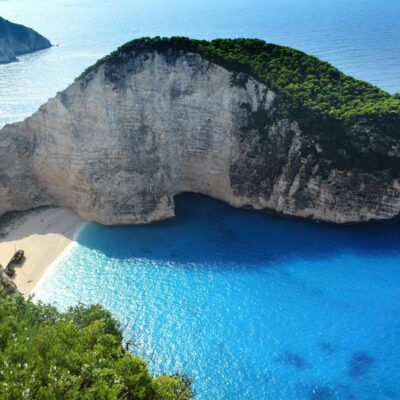 A breathtaking aerial view of Navagio Beach with turquoise waters and lush greenery.