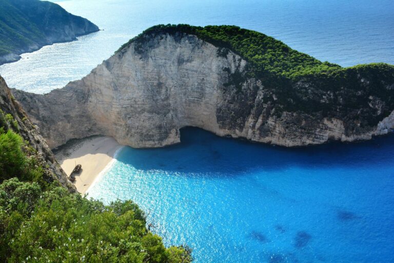 A breathtaking aerial view of Navagio Beach with turquoise waters and lush greenery.